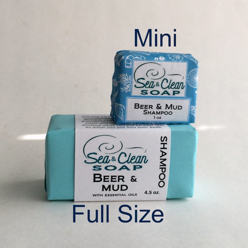 Two bars of soap, one full size and one mini. Both bars are blue and feature the text 'Sea & Clean Soap' and 'Beer & Mud' with the full size bar also stating 'With Essential Oils'. The full size bar is 4.5 oz and the mini bar is 1 oz. Both bars are labeled 'Shampoo'.