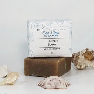 May include: A bar of brown soap with a white label that reads "Sea & Clean Soap" and "Juniper Soap with essential oil 1 oz."