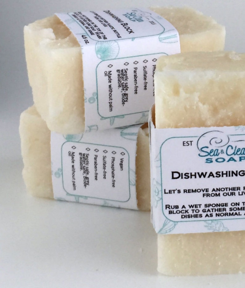 May include: Three bars of white dish soap with labels that say "Sea & Clean Soap" and "Dishwashing". The label also says "Let's remove another film from our lives" and "Rub a wet sponge on the block to gather some suds and wash dishes as normal."