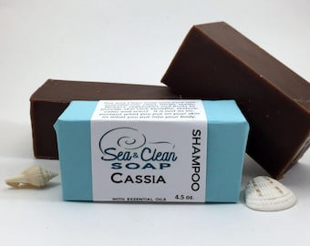 May include: Two bars of brown shampoo soap with a blue label that reads "Sea & Clean Soap Cassia with Essential Oils 4.5 oz. Shampoo".