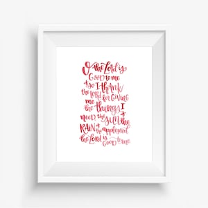 May include: A red and pink watercolor print with a handwritten quote that reads "O the Lord is Good to me so I thank the Lord for giving me the things I need, the sun the rain the appleseed. The Lord is Good to me."