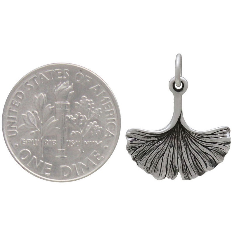 May include: A silver charm in the shape of a ginkgo leaf. The charm is about the size of a dime.