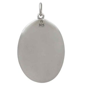Op de afbeelding: Zilverkleurige hanger met een ovale vorm en een lus aan de bovenkant voor een ketting. De achterkant van de hanger is voorzien van de tekst "n 925". Eenvoudig, elegant ontwerp.