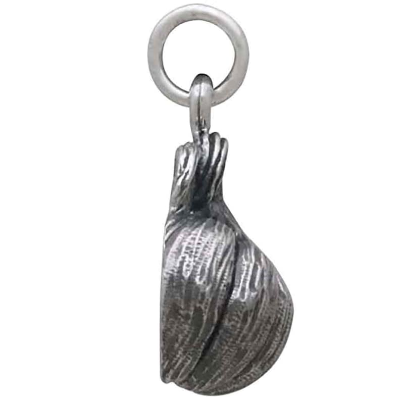 May include: A silver charm in the shape of a garlic bulb. The charm has a detailed, textured surface and a loop at the top for attaching to a bracelet or necklace.
