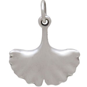 May include: A silver charm in the shape of a ginkgo leaf. The charm has a loop at the top for attaching to a bracelet or necklace.