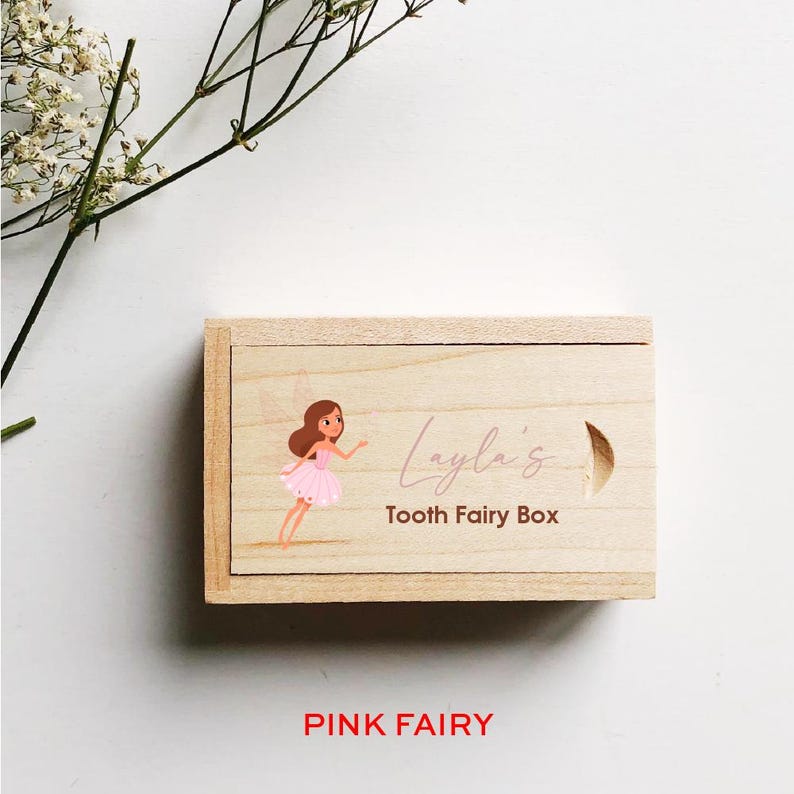 May include: A wooden tooth fairy box with a pink fairy illustration and the text "Layla's Tooth Fairy Box".