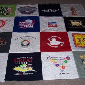 May include: A quilt made from a variety of t-shirts, each with a different design and text. The quilt is made up of 16 squares, with each square featuring a different t-shirt. The t-shirts feature a variety of designs, including logos, slogans, and images. The quilt is a great way to commemorate special events or to show off your favorite t-shirts.