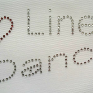 May include: A red heart made of rhinestones with the words "Line Dancing" spelled out in silver rhinestones.