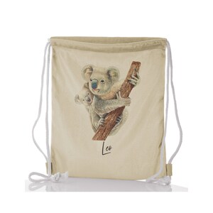 Puede incluir: Una bolsa de cordón beige con una ilustración de acuarela de dos koalas en una rama. La bolsa tiene cordones de ajuste blancos y el nombre "Leo" está escrito en cursiva en la parte inferior.