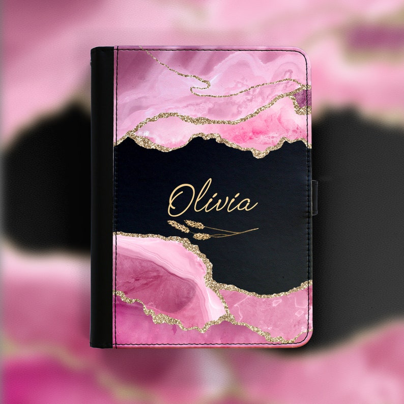 Peut inclure: Une housse de tablette personnalis&eacute;e rose et noire avec un motif de paillettes dor&eacute;es et le nom "Olivia" &eacute;crit en lettres dor&eacute;es.