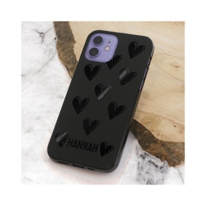 May include: Black phone case with a pattern of black hearts and the name "HANNAH" printed in white.