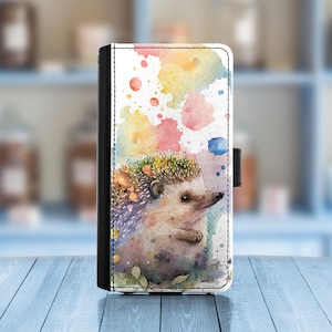 Könnte beinhalten: Eine Handyhülle aus Aquarell mit einem niedlichen Igel auf einem bunten Hintergrund aus Aquarellspritzer.
