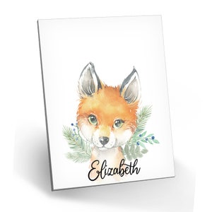 Puede incluir: Pintura acuarela de un zorro con ojos verdes y un borde floral de hojas. El nombre "Elizabeth" est&aacute; escrito en cursiva debajo del zorro.