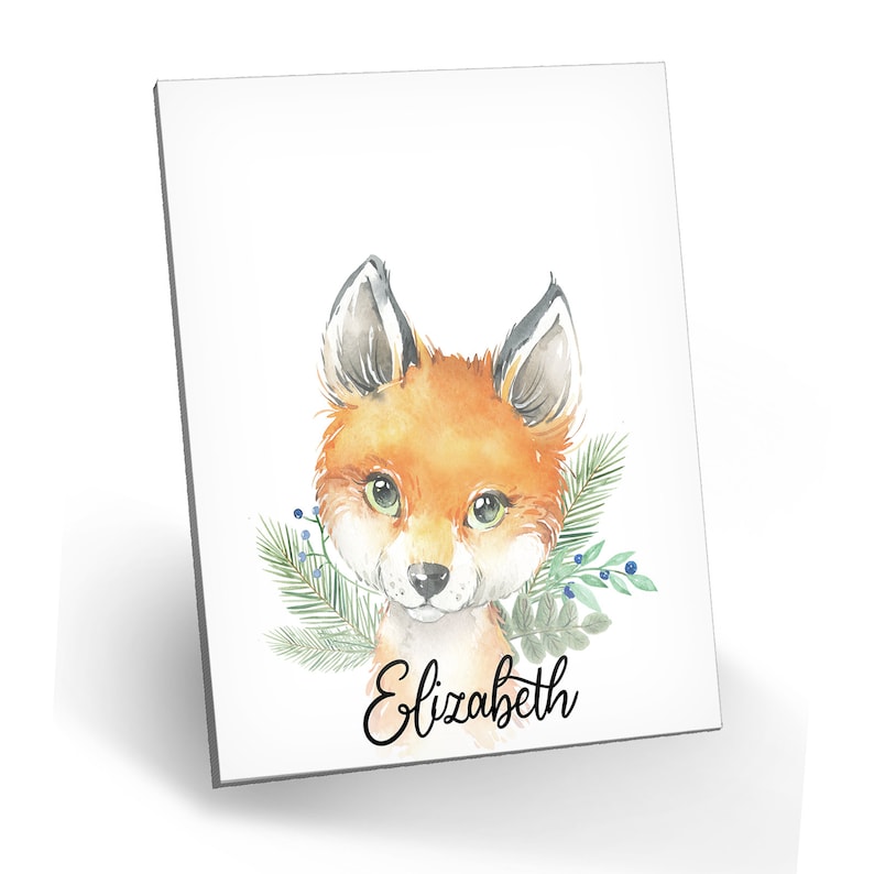 Puede incluir: Pintura acuarela de un zorro con ojos verdes y un borde floral de hojas. El nombre "Elizabeth" est&aacute; escrito en cursiva debajo del zorro.