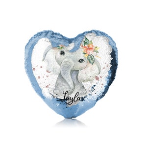 Może przedstawiać: Poduszka w kształcie serca z niebieskich cekinów z akwarelową ilustracją szarego słonia w koronie kwiatowej. Nazwa "Layla" jest napisana czarnym, ozdobnym pismem pod słoniem.