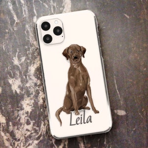 May include: A white iPhone case with a brown Labrador Retriever illustration and the name "Leila" printed on it.