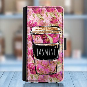 Può includere: Una custodia per telefono floreale rosa e oro con un design a tazza di caffè. La tazza di caffè ha il nome "Jasmine" scritto su di essa.