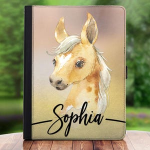 May include: A brown and white horse with a white mane and tail. The horse has a spotted pattern on its body. The horse's head is turned to the side and its eyes are closed. The horse's name, "Sophia", is written in black cursive on the bottom of the image.