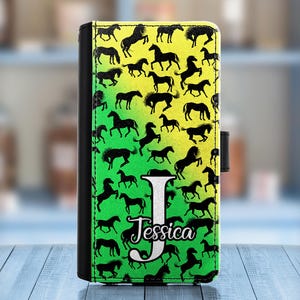 May include: Black and white silhouette horse pattern on a yellow and green phone case with the name Jessica in white lettering.