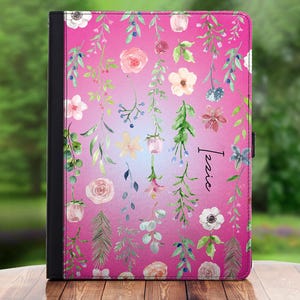 Pode incluir: Uma capa para tablet ou laptop com um design floral rosa e azul sobre um fundo branco e preto. O nome "Lexie" está escrito em branco na capa.