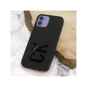 May include: Black phone case with the initials "CK" printed in a bold, black font.
