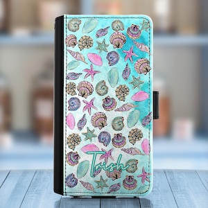 Könnte beinhalten: Eine blaue und weiße Handyhülle mit einem Muschelmuster und dem Namen "Trish" darauf gedruckt.