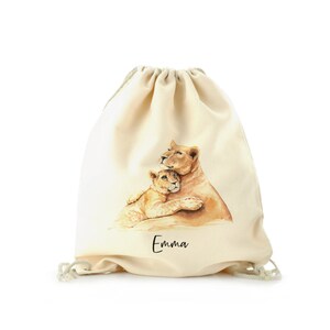May include: A beige drawstring bag with a watercolor illustration of a lioness and her cub. The bag has the name "Emma" printed on the front.