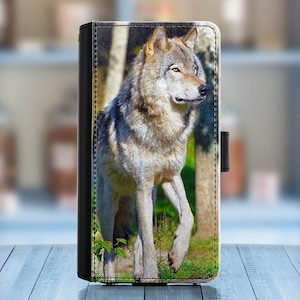 以下が含まれることがあります： 茶色の模様のある灰色のオオカミが森の中に立っています。オオカミは画像の右を見ています。オオカミはピントが合っていますが、背景はぼやけています。