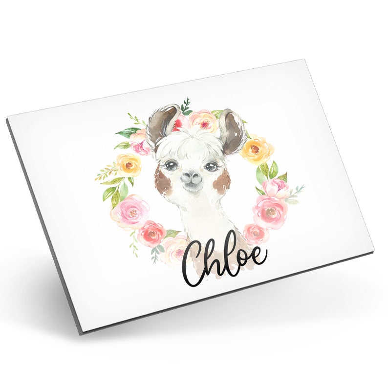 Puede incluir: Una ilustraci&oacute;n de acuarela de una llama con una corona de flores alrededor de su cabeza. La llama tiene orejas marrones y una nariz marr&oacute;n. La corona est&aacute; hecha de flores rosas, amarillas y blancas. El texto "Chloe" est&aacute; escrito debajo de la llama.