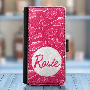 May include: A pink phone case with a white glitter background and the name "Rosie" in white text. The case features a pink and white pattern of lips, cars, and sunglasses.