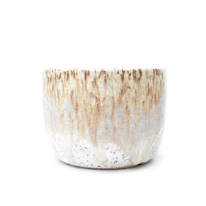 May include: A ceramic, cylindrical planter with a speckled white base and a gradient of brown and beige tones. The glaze drips down the sides, creating a textured appearance. The planter is suitable for small plants and succulents.