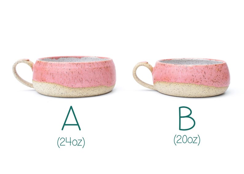 May include: Two handmade ceramic mugs with a pink speckled glaze and a cream-colored base. The mugs have a rounded shape with a handle. The text "A (24oz)" and "B (20oz)" are below the mugs.
