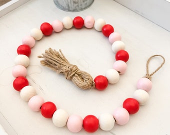 Guirlande de perles de la Saint-Valentin, décor rouge et rose de la Saint-Valentin, décor de plateau à plusieurs niveaux de la Saint-Valentin, guirlande de perles de bois avec glands