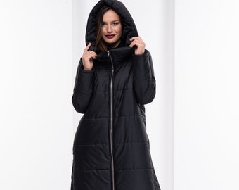 May include: A long black puffer coat with a hood. The coat has a zipper closure and a quilted design.