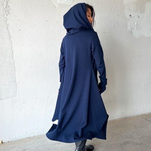 Wrap yourself in effortless style with our long hooded cardigan cloak—a piece that fuses high fashion with everyday practicality. This asymmetrical, draped design offers a distinctive silhouette that flatters all shapes, making it our best-selling garment and a statement piece in any wardrobe. Made from a soft, mid-weight knit fabric, the cloak has a luxurious, skin-friendly feel and flows beautifully with every movement.