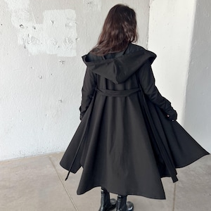 Introducing our cotton hooded cloak, designed with your comfort and style in mind.  Handcrafted with premium cotton, this cloak features thumb holes for added warmth, side pockets for your essentials, and a matching belt for a tailored look.