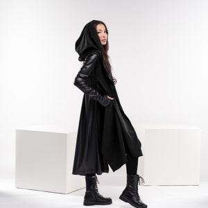 May include: A black hooded coat with long sleeves and a flowing design. The coat is made of a soft, luxurious fabric and has a sleek, modern look.