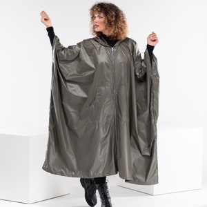 May include: A hooded, long, olive green raincoat with a zipper closure and pockets. The raincoat is made of a shiny, water-resistant material.