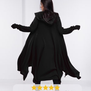 以下が含まれることがあります： 長袖で、フード付きの黒いカーディガン。裾は流れるような非対称のデザイン。柔らかく快適な生地で、ゆったりとしたフィット感です。