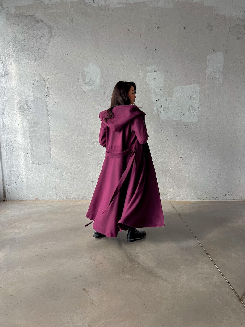 Long Hooded Princess coat made from soft wool winter fabric in burgundy color here. With belt and side pockets.
