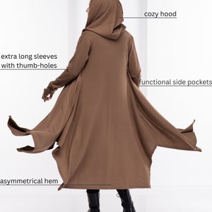 May include: A brown hooded cardigan with extra long sleeves and thumb holes. The cardigan has a cozy hood, functional side pockets, and an asymmetrical hem.