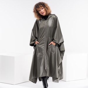 May include: A long, hooded, olive green raincoat with a zipper closure and two pockets. The raincoat is made of a shiny, water-resistant material.