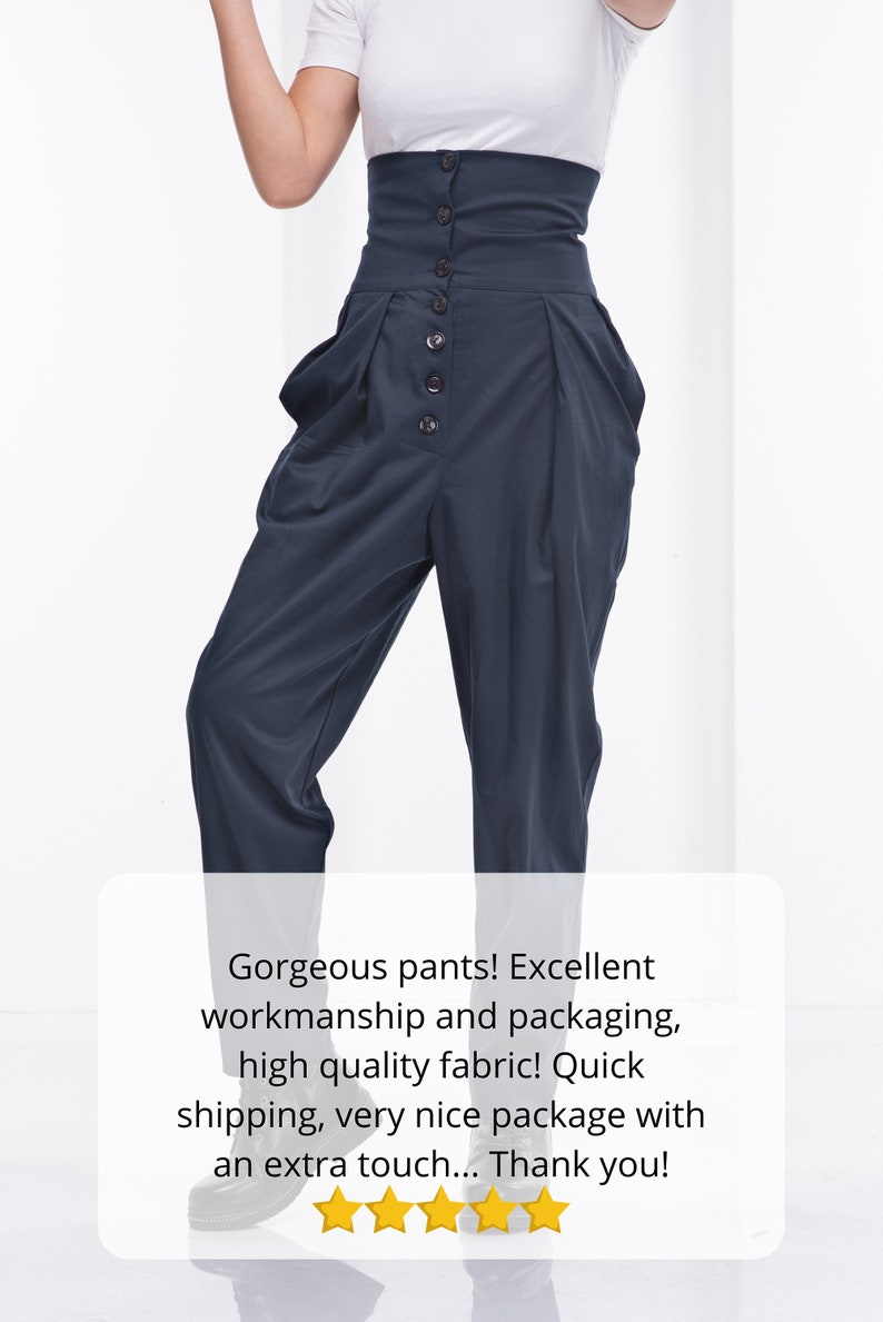 Pu&ograve; includere: Pantaloni blu navy a vita alta con chiusura a bottoni. I pantaloni hanno un'ampia cintura e pieghe sul davanti. La modella indossa una maglietta bianca. I pantaloni sono realizzati in tessuto di alta qualit&agrave;.