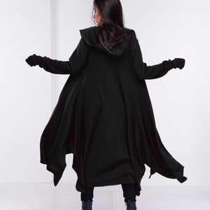 May include: A black hooded cardigan with long sleeves and a flowing design. The cardigan is made of a soft, comfortable fabric and has a relaxed fit.