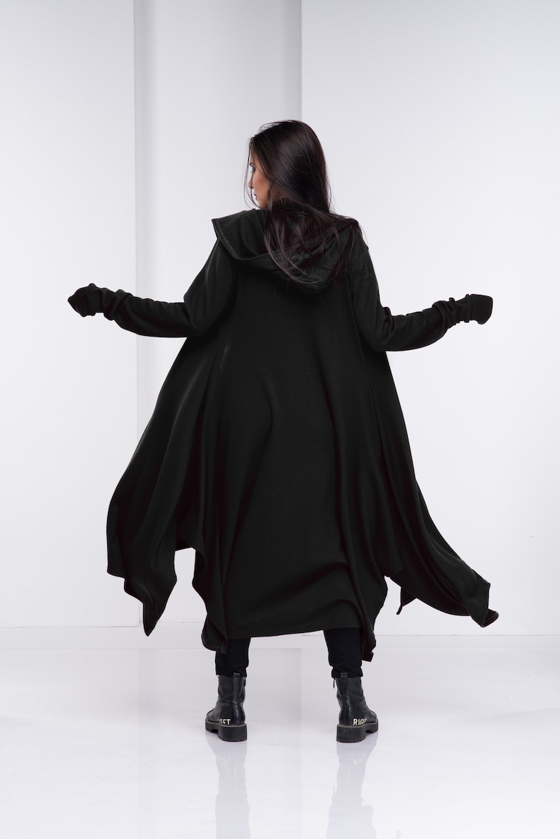 May include: A black hooded cardigan with long sleeves and a flowing design. The cardigan is made of a soft, comfortable fabric and has a relaxed fit.