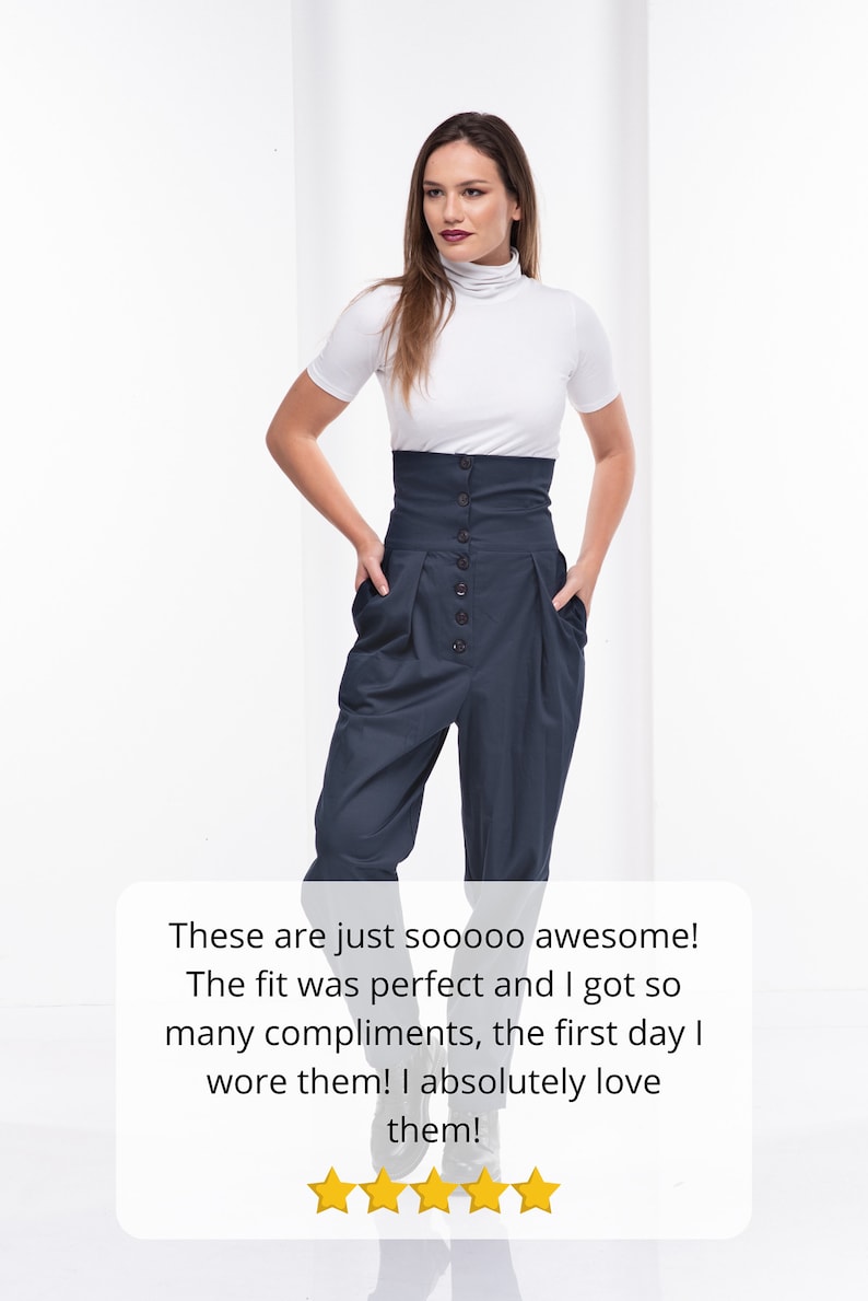 Pu&ograve; includere: Una donna indossa un top bianco a maniche corte e dolcevita e pantaloni blu navy a vita alta con bottoni. I pantaloni hanno tasche e un design a pieghe. L'immagine include il testo che dice "These are just sooooo awesome!"