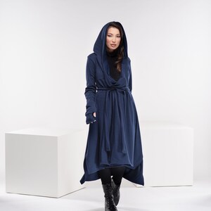 May include: A long, navy blue hooded cardigan with a tie belt and thumbholes. The cardigan is made of a soft, comfortable fabric and has a relaxed fit.