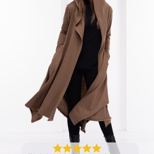 May include: A long brown hooded cardigan with a draped front. The cardigan is made of a soft, stretchy fabric and has a relaxed fit.
