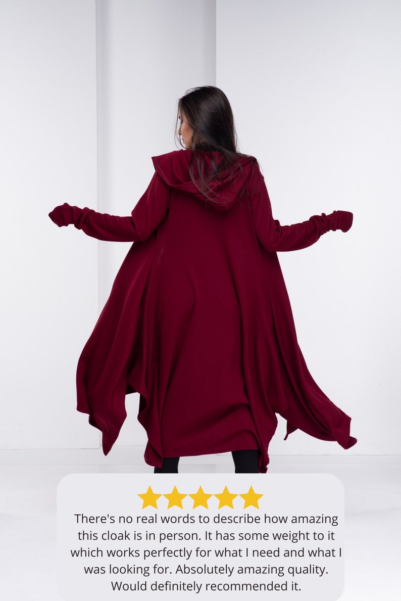 May include: A burgundy hooded cloak with long sleeves and a flowing design. The cloak is made of a soft, comfortable fabric and has a relaxed fit.