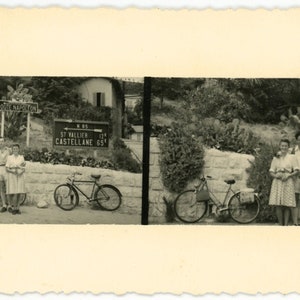 May include: A black and white photograph of three people standing in front of a sign that reads "Route Napoleon". The sign is on a wooden post. The people are standing next to two bicycles. The sign also indicates distances to St. Vallier and Castellane.